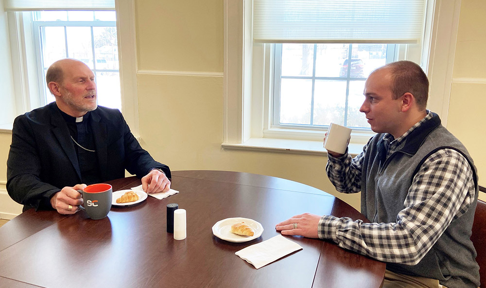Bishop Thomas Zinkula of Davenport, Iowa, and Patrick Schmadeke, diocesan director of evangelization, have a conversation Jan. 28 about the diocese's "58,000 Cups of Coffee" initiative. (CNS/The Catholic Messenger/Barb Arland-Fye)