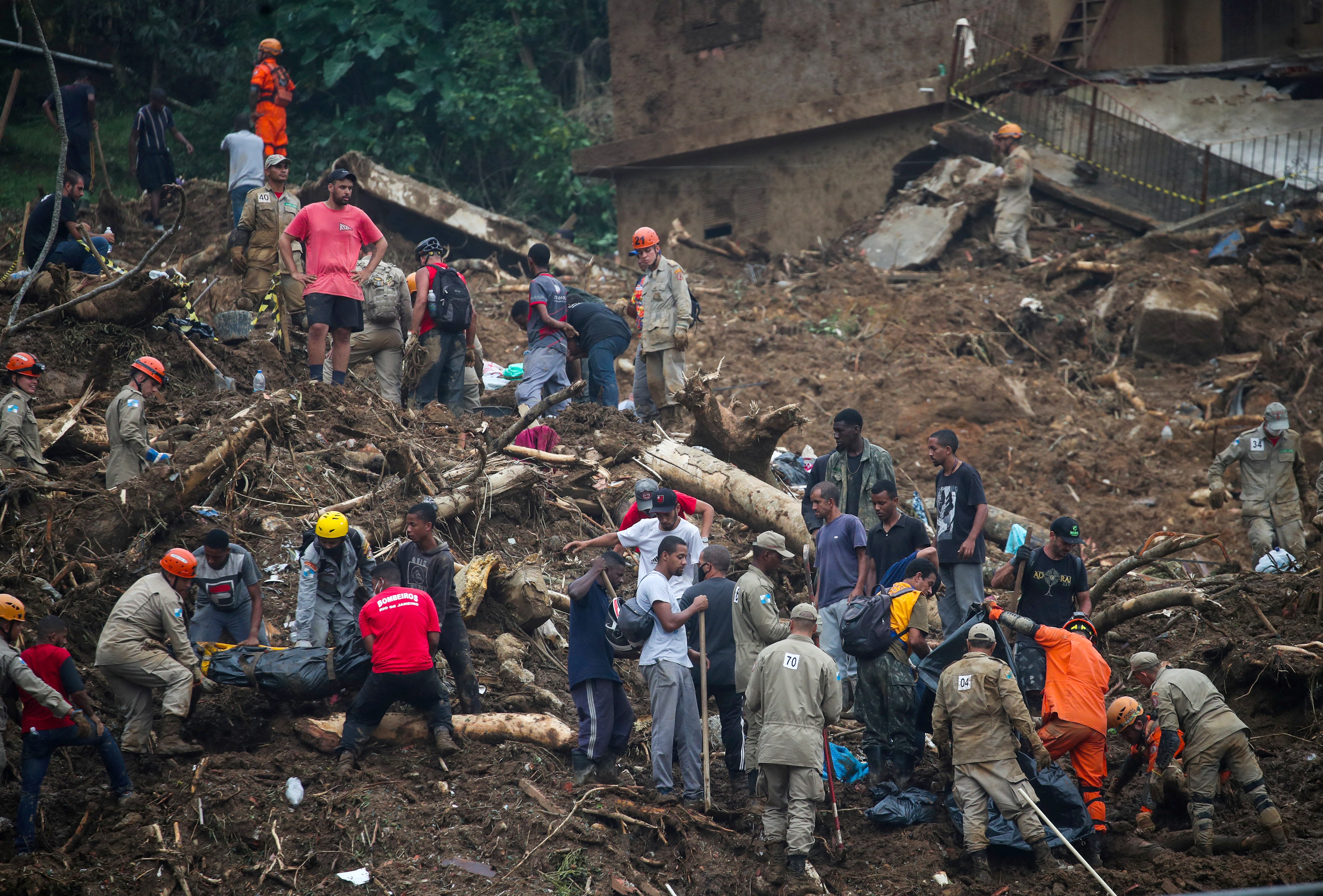 Rescue workers and residents remove a body at the site of a mudslide in Petrópolis, Brazil, Feb. 16, 2022. (CNS photo/Ricardo Moraes, Reuters)