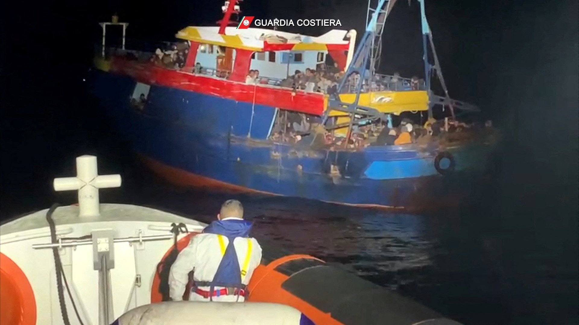 Migrants wait to be rescued by Italian coast guard during a search and rescue operation off the coast of Italy, Feb. 22, 2022, in this screen grab taken from a handout video. (CNS photo/Italian Coast Guard/handout via Reuters)