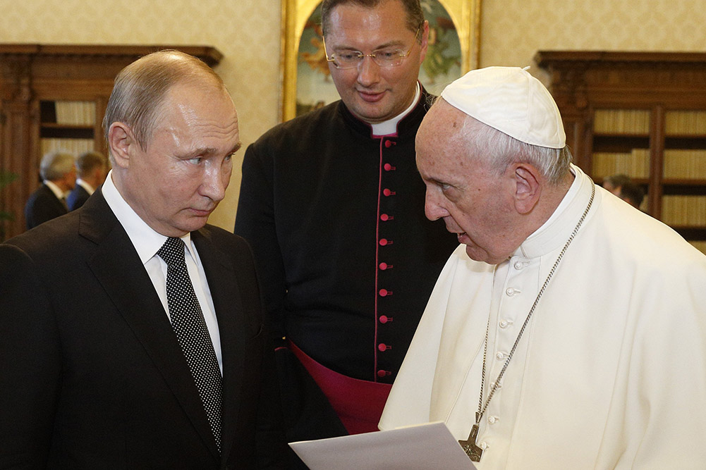 Then-Msgr. Visvaldas Kulbokas, center, serves as translator as Pope Francis and Russian President Vladimir Putin exchange gifts during a private audience at the Vatican July 4, 2019. (CNS/Paul Haring)
