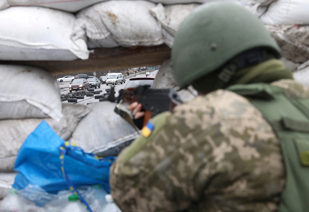 A member of the Territorial Defense Forces in Kyiv, Ukraine, stands guard at a checkpoint March 3, as Russia's invasion of Ukraine continues. (CNS/Reuters/Mykola Tymchenko)