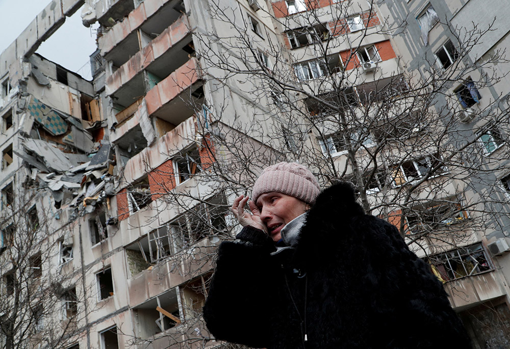 A woman reacts in front of destroyed apartment buildings March 17 in Mariupol, Ukraine. (CNS/Reuters/Alexander Ermochenko)