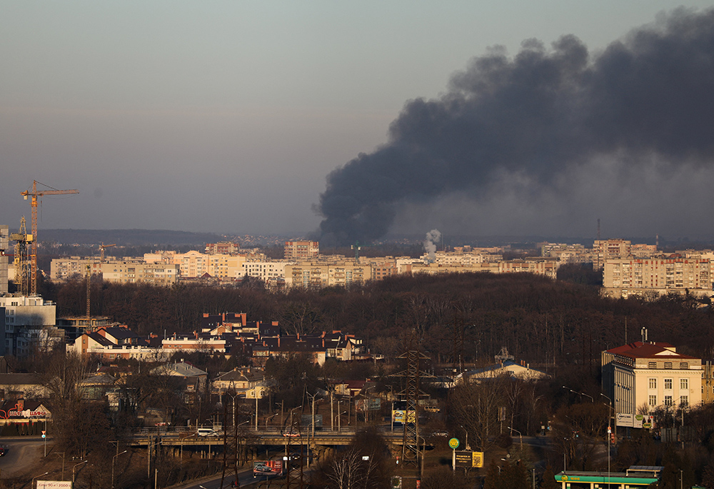 Smoke rises above buildings near the Lviv airport, as Russia's invasion of Ukraine continues, March 18 in Lviv, Ukraine. (CNS/Reuters/Roman Baluk) Smoke rises above buildings near the Lviv airport, as Russia's invasion of Ukraine continues, March 18 in Lviv, Ukraine. (CNS/Reuters/Roman Baluk)