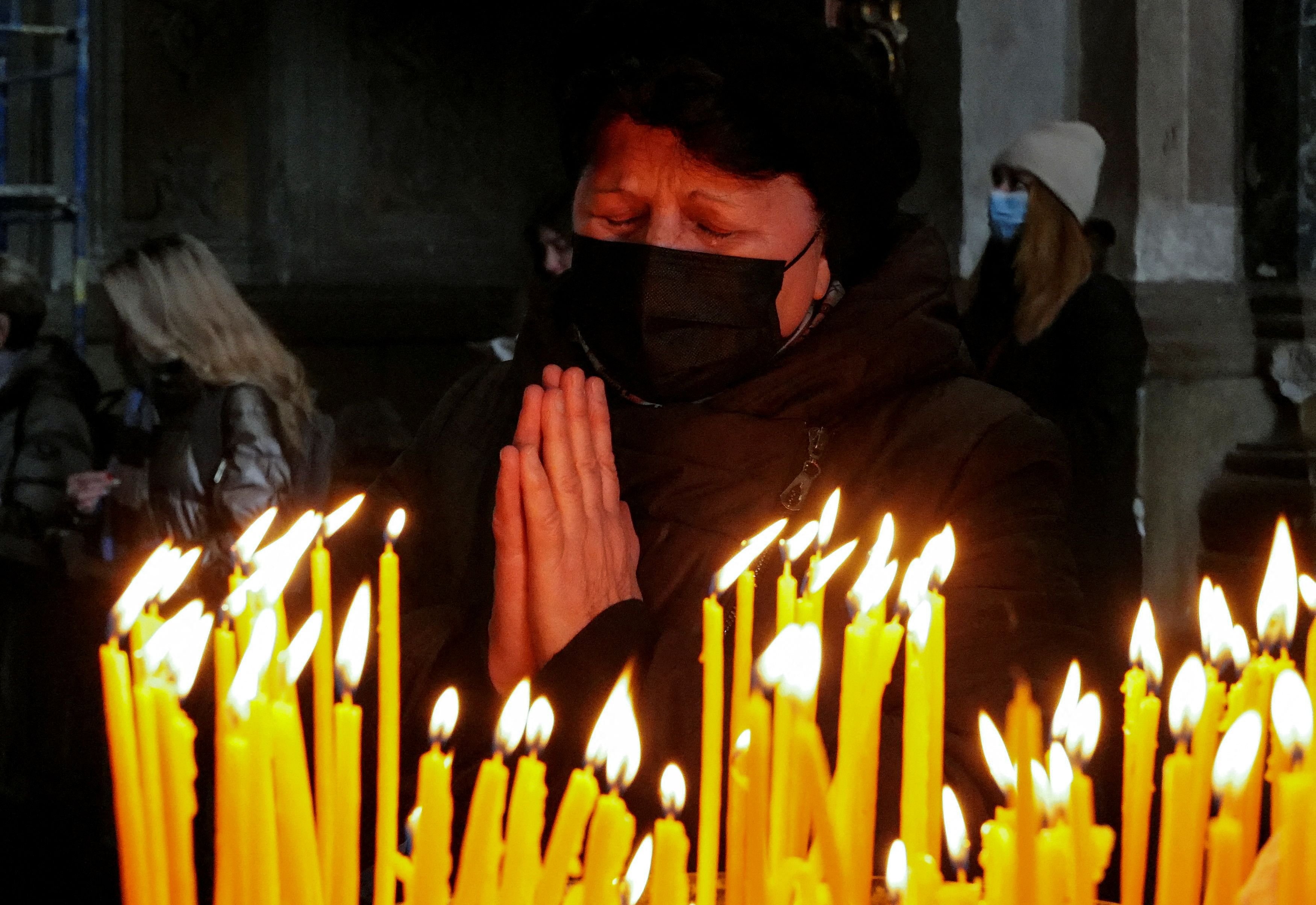 A woman prays at the Catholic Church of the Holy Apostles Peter and Paul in Lviv, Ukraine, March 20, 2022, during Russia's invasion of Ukraine. (CNS photo/Zohra Bensemra, Reuters)