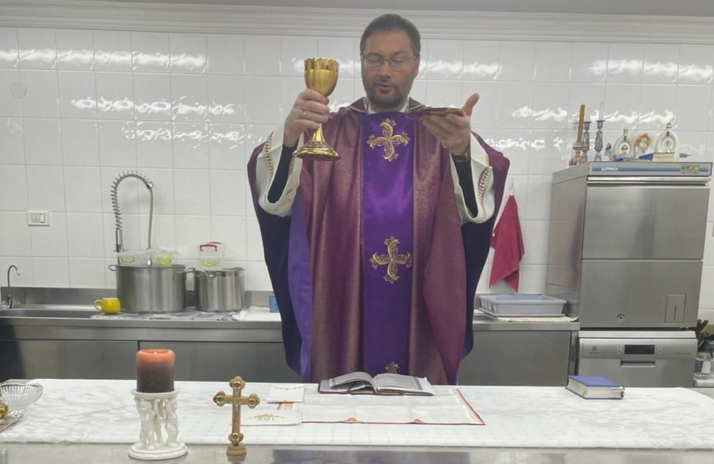 Archbishop Visvaldas Kulbokas, apostolic nuncio to Ukraine, elevates the Eucharist in the kitchen at the apostolic nunciature in Kyiv, Ukraine, in this recent photo.