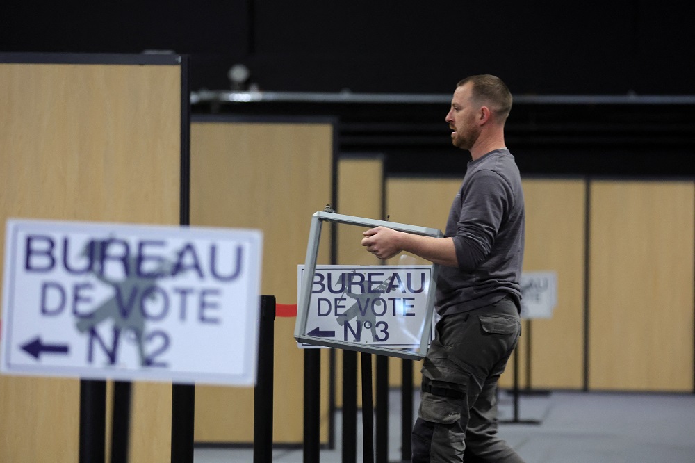 A worker carries a ballot box as he prepares the polling station in Le Touquet-Paris-Plage, France, April 6, for the April 10 presidential election. 