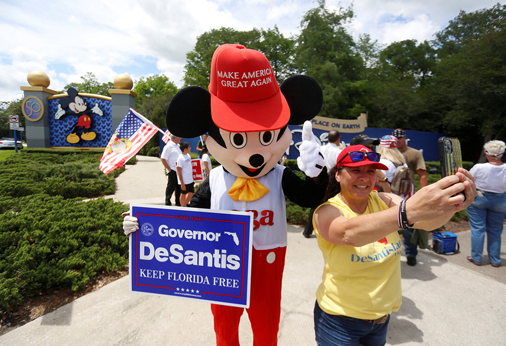 : A person outside Walt Disney World in Orlando, Florida, wears a mouse costume and takes selfies with supporters of Florida's Parental Rights in Education law April 16. (CNS/Reuters/Octavio Jones)