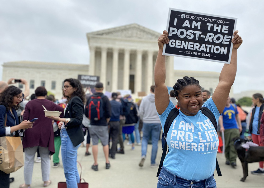 Norvilia Etienne, of Students for Life, holds a sign outside the Supreme Court of the United States May 3, the day after a draft of the court's opinion was leaked signaling that the court was leaning toward overturning Roe v. Wade. (CNS/Rhina Guidos)