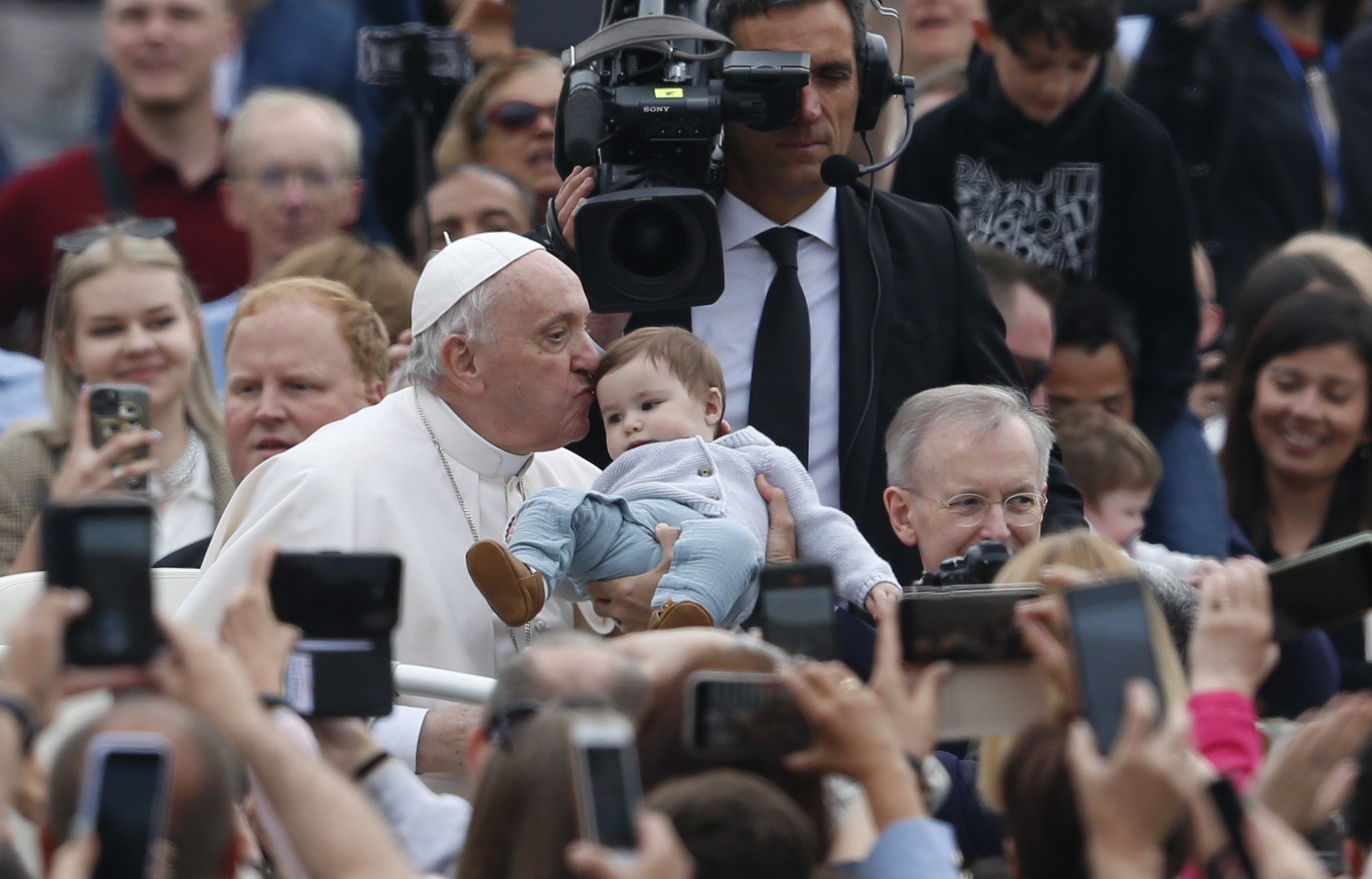 Pope Francis kisses a baby as he greets the crowd during his general audience in St. Peter's Square at the Vatican May 4, 2022. (CNS photo/Paul Haring)