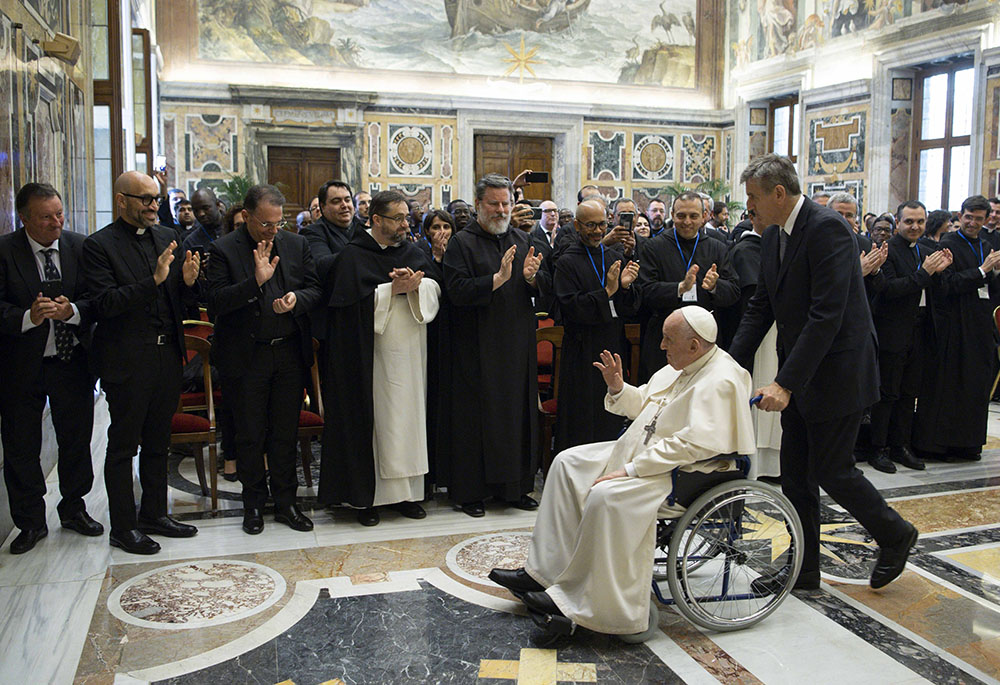 Pope Francis is pushed in a wheelchair by his aide, Sandro Mariotti, as he leaves an audience with students and professors of Rome's Pontifical Institute of Liturgy at St. Anselm, May 7 at the Vatican. (CNS/Vatican Media)