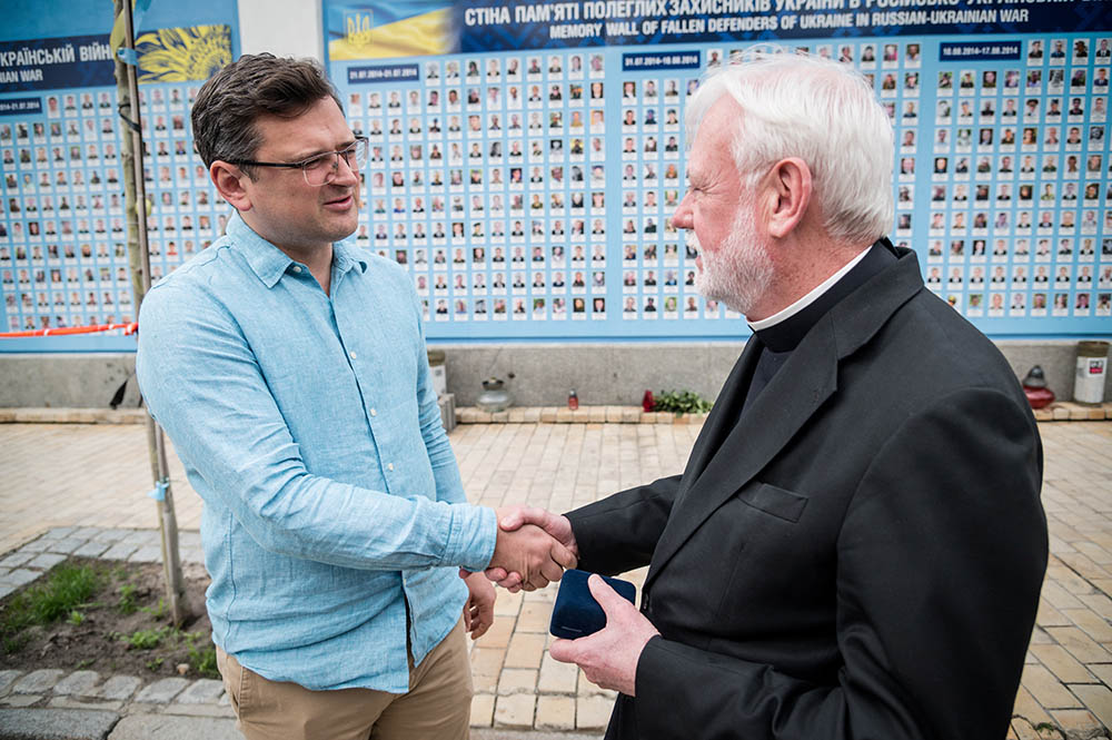Archbishop Paul Gallagher, Vatican foreign minister, and Dmytro Kuleba, Ukraine's foreign minister, shake hands after paying tribute to killed Ukrainian soldiers near the Wall of Remembrance in Kyiv, Ukraine, May 20. (CNS/Handout via Reuters)