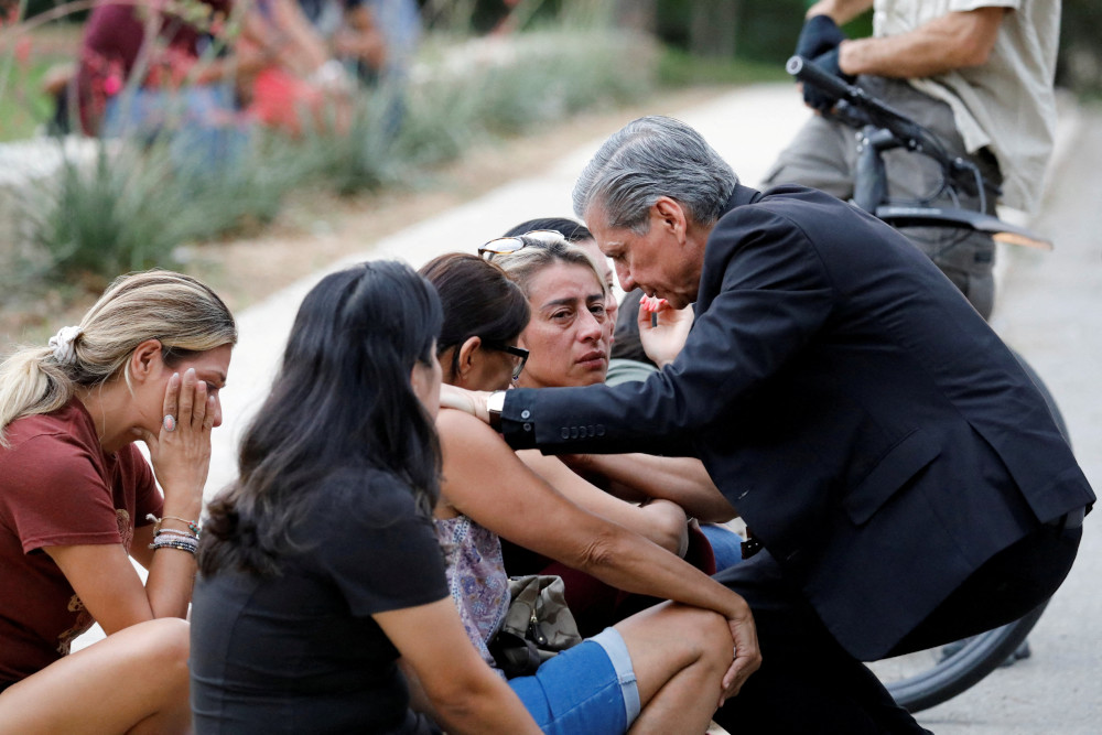 Archbishop Gustavo García-Siller of San Antonio comforts people outside the SSGT Willie de Leon Civic Center, where students had been transported from Robb Elementary School after a shooting, in Uvalde, Texas, May 24. (CNS/Reuters/Marco Bello)