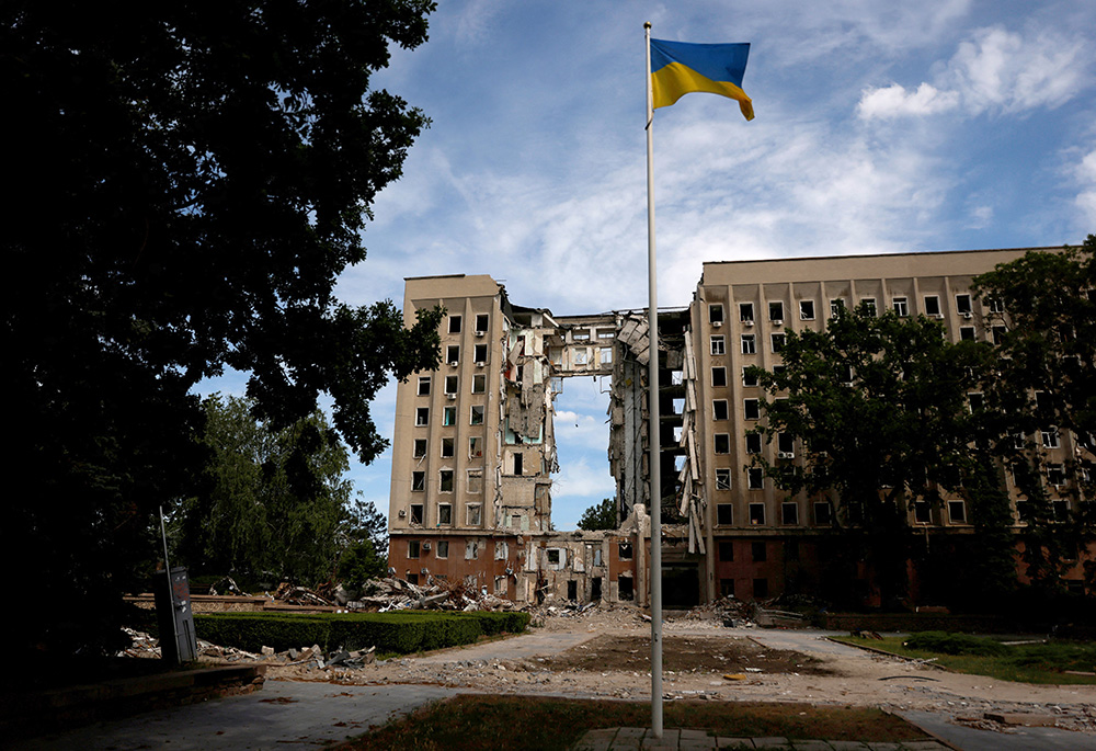 A Ukrainian flag flies in front of the destroyed regional administration building following shelling by Russian troops June 8 in Mykolaiv, Ukraine. (CNS/Reuters/Edgar Su)