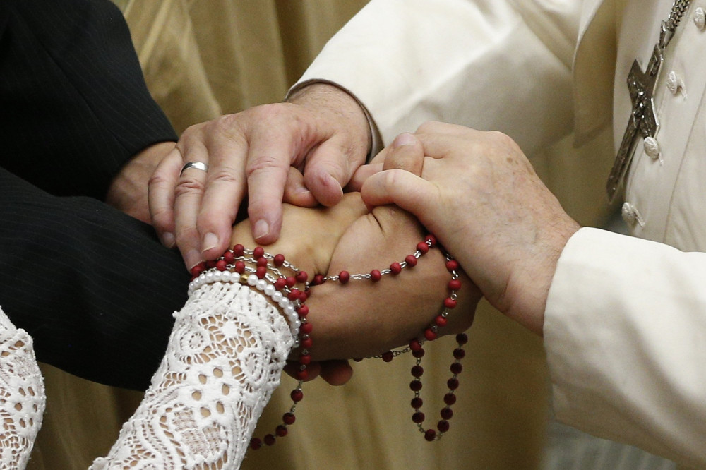 Pope Francis touches the hands of a newly married couple during his general audience in Paul VI hall at the Vatican Dec. 18, 2019. (CNS/Paul Haring)