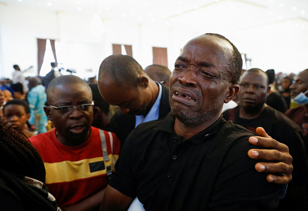 A man cries during a funeral Mass in the parish hall of St. Francis Xavier Church in Owo, Nigeria, June 17. The Mass was for at least 50 victims killed in a June 5 attack by gunmen during Mass at the church. (CNS/Reuters/Temilade Adelaja)