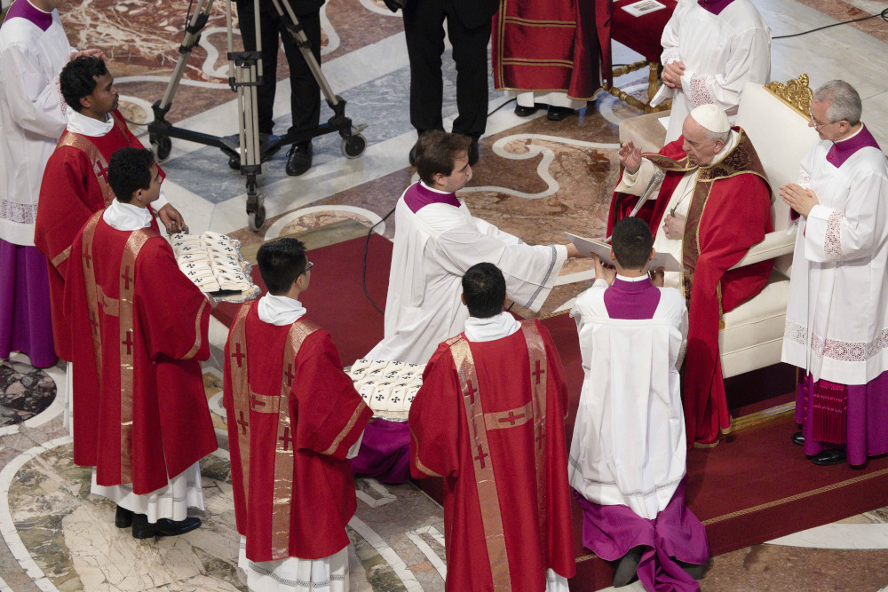 Pope Francis blesses palliums that deacons hold on trays during Mass June 29 in St. Peter's Basilica at the Vatican. (CNS/Vatican Media)