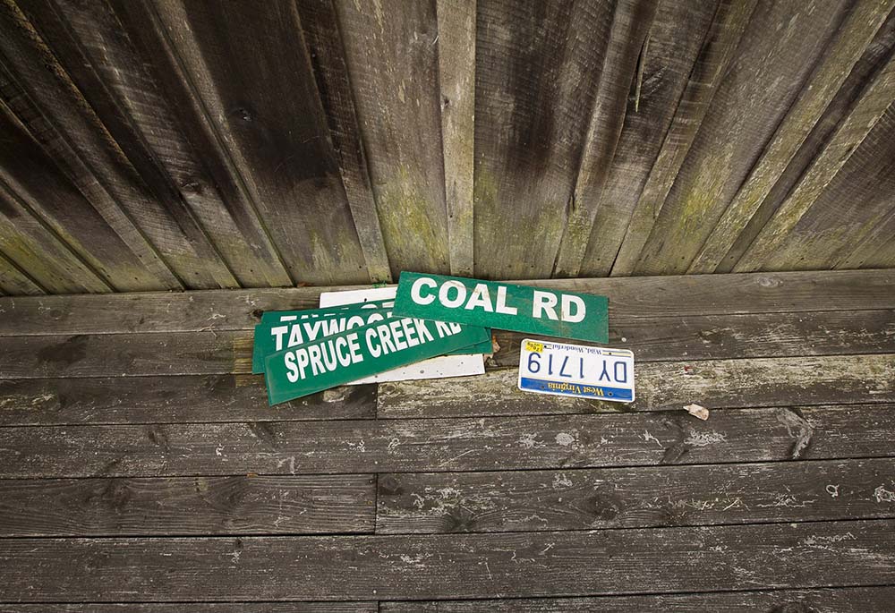 Road signs rest on the side porch of a house near Kermit, West Virginia, Aug. 20, 2014. The Supreme Court ruled in West Virginia v. Environmental Protection Agency on June 30, 2022, to limit EPA's ability to regulate carbon emissions from power plants.