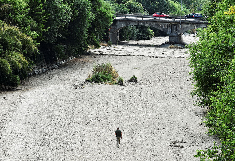 A man walks on the dry riverbed of the Sangone River, a tributary of the Po River, June 19 in Beinasco, Turin, Italy. Italy is experiencing its worst drought in 70 years. (CNS/Reuters/Massimo Pinca) A man walks on the dry riverbed of the Sangone River, a tributary of the Po River, June 19 in Beinasco, Turin, Italy. Italy is experiencing its worst drought in 70 years. (CNS/Reuters/Massimo Pinca)