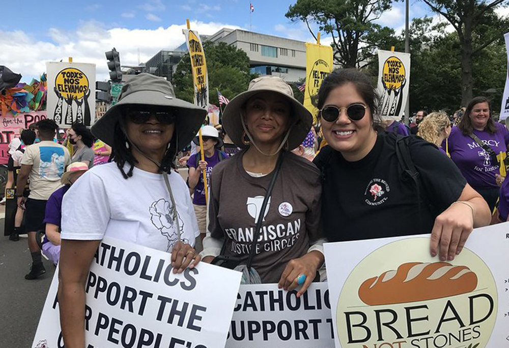 Charlene Howard, chairwoman of the Pax Christi USA national council, Josie Garnem, a national council member, and Lauren Bailey, the organization's national field organizer, pose during a demonstration June 18 in Washington. (CNS)