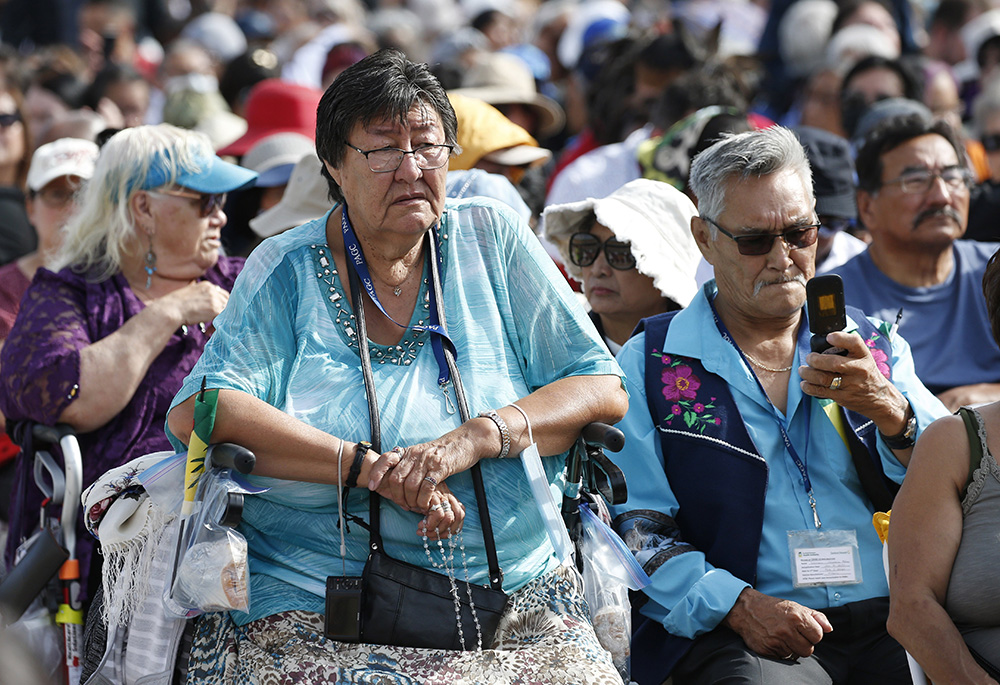 A woman holds a rosary as people wait for the start of Pope Francis' celebration of Mass at Commonwealth Stadium July 26 in Edmonton, Alberta. (CNS/Paul Haring)