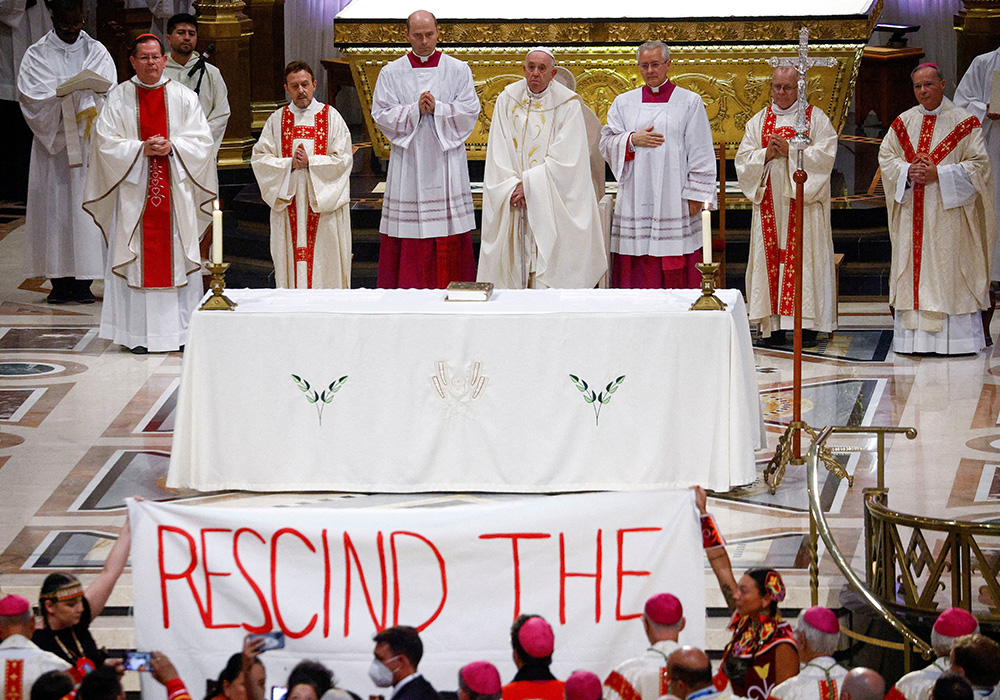 Indigenous people hold a banner calling on Pope Francis to "rescind the doctrine" during a papal Mass at the Basilica of Ste. Anne de Beaupré July 28 in Quebec. (CNS/Reuters/Guglielmo Mangiapane) Indigenous people hold a banner calling on Pope Francis to "rescind the doctrine" during a papal Mass at the Basilica of Ste. Anne de Beaupré July 28 in Quebec. (CNS/Reuters/Guglielmo Mangiapane)