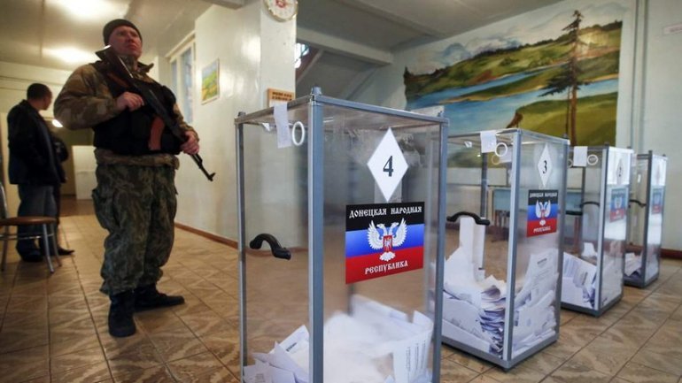 A Russian soldier stands guard at a polling station in Ukraine's Donetsk region Sept. 23, 2022.