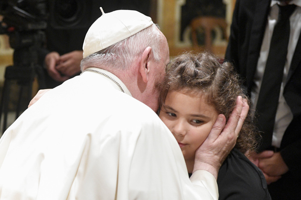 Pope Francis greets a child during an audience with members of the Fraternity of St. Thomas Aquinas Groups from Argentina in the Vatican's Clementine Hall Sept. 30, 2022