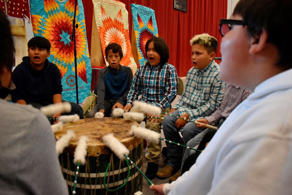 Students from Rosebud Elementary School perform in a drum circle during a meeting about abusive conditions at Native American boarding schools at Sinte Gleska University on the Rosebud Sioux Reservation in Mission, S.D.