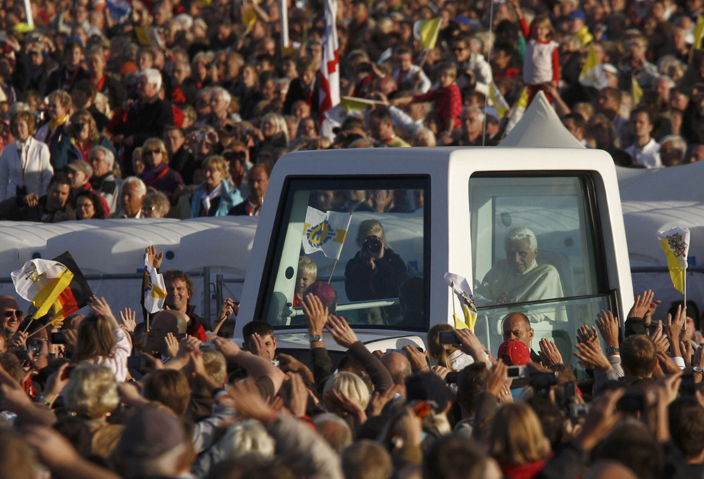 Pope Benedict XVI waves to the crowd from inside his popemobile as he arrives for an evening prayer service at the Marian sanctuary of Etzelsbach in Germany Sept. 23, 2011, as part of a four-day visit to his homeland. (CNS/Reuters/Alex Domanski)