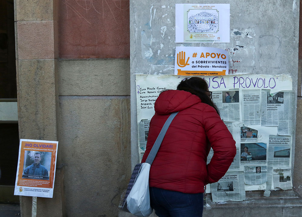 A woman reads a sign outside a courthouse Aug. 5, 2019, during the beginning of the trial of Catholic priests and a school employee, who were later convicted of sexual abuse that took place between 2004 and 2016 at the Antonio Provolo School for Deaf and Hearing Impaired Children in Mendoza, Argentina. (CNS/Reuters)
