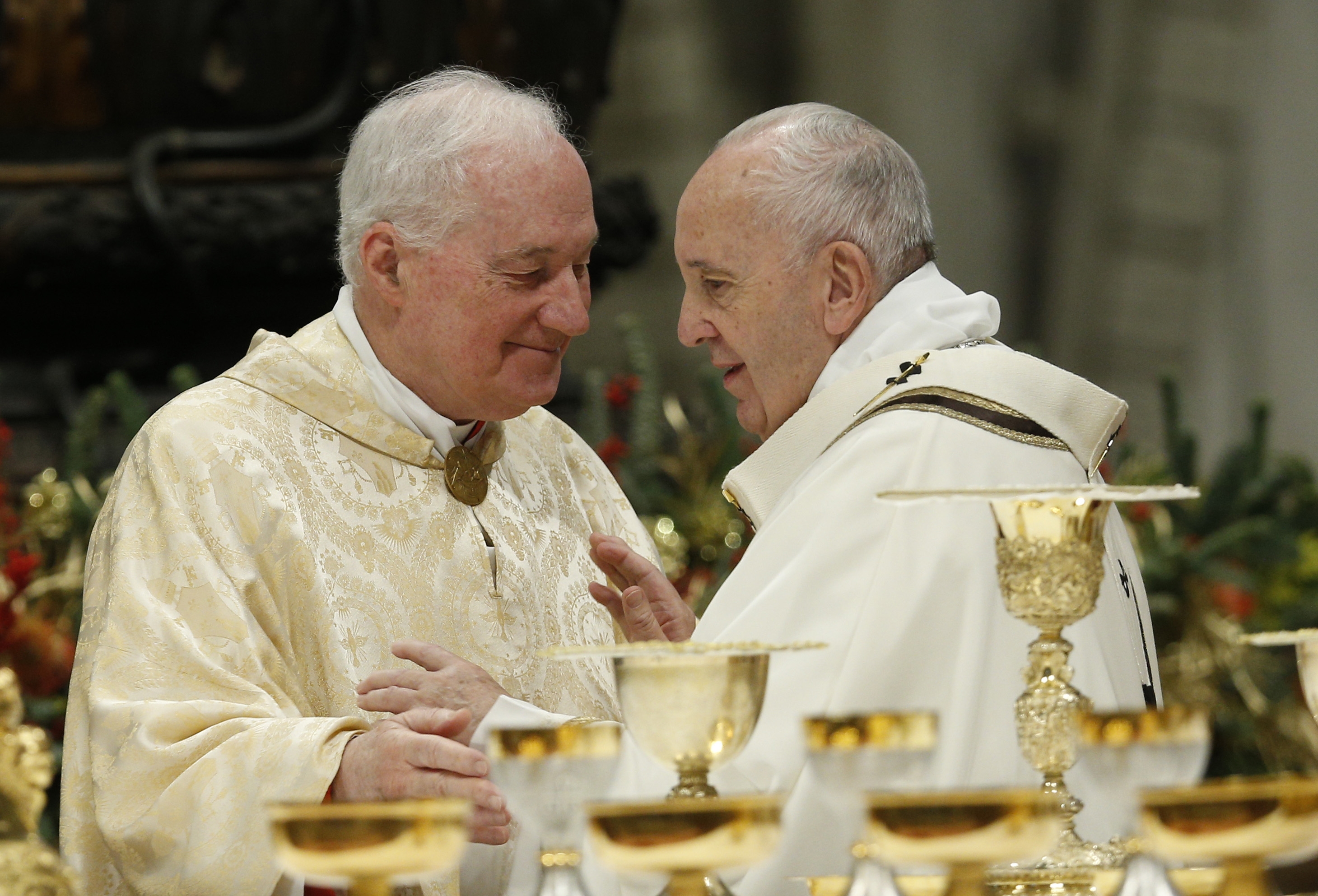 Pope Francis greets Cardinal Marc Ouellet, prefect of the Congregation for Bishops, during the sign of peace as he celebrates Mass marking the feast of the Epiphany in St. Peter's Basilica at the Vatican Jan. 6, 2020. (CNS photo/Paul Haring)