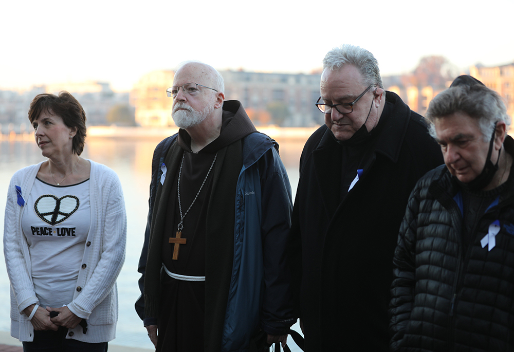 Jesuit Fr. Jerry McGlone, second from right, is seen with Jennifer Wortham, far left, and Cardinal Sean O'Malley of Boston, president of the Pontifical Commission for the Protection of Minors, in prayer during a sunrise walk to end abuse Nov. 18, 2021, outside the hotel in Baltimore where the U.S. Conference of Catholic Bishops held its fall general assembly Nov. 15-18. (CNS/Bob Roller)
