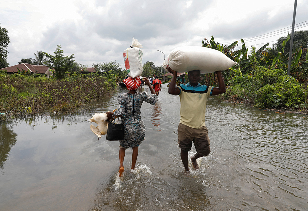 Residents wade through floodwater Oct. 22, 2022, in Ahoada, Nigeria. (CNS/Reuters/Temilade Adelaja)