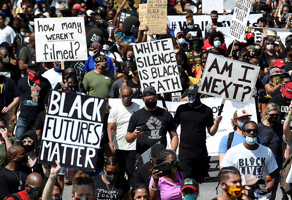 People hold placards in Washington Aug. 28, 2020, during the "Get Your Knee Off Our Necks" Commitment March on Washington 2020 in support of racial justice. (CNS/Olivier Douliery/pool via Reuters)