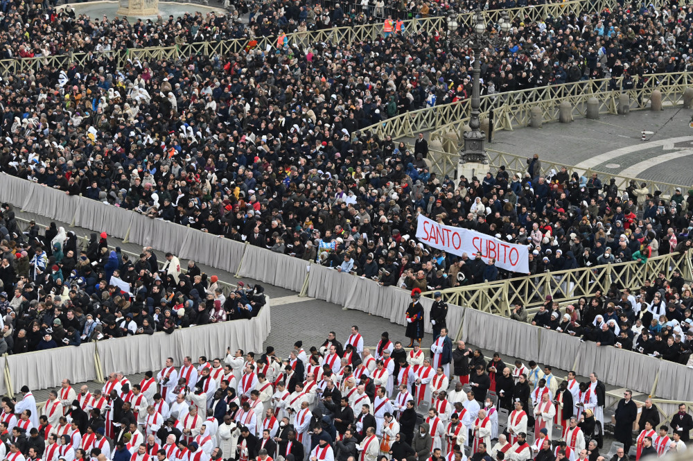 People hold up a sign saying, "Santo Subito" (Sainthood Now) as Pope Francis concludes the funeral Mass for Pope Benedict XVI in St. Peter's Square at the Vatican Jan. 5, 2023. (CNS photo/Chris Warde-Jones)