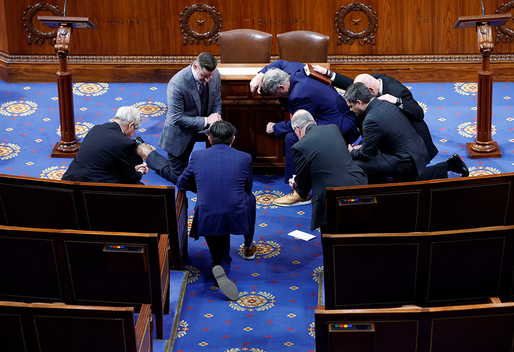 Members kneel in prayer prior to a 12th round of voting for a new Speaker of the House of Representatives, on the fourth day of the 118th Congress at the U.S. Capitol Jan. 6 in Washington. (CNS/Reuters/Evelyn Hockstein)