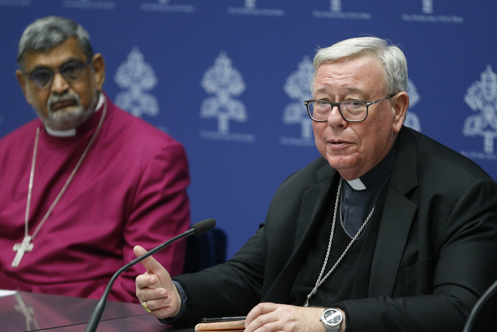 Cardinal Jean-Claude Hollerich of Luxembourg, relator general of the Synod of Bishops, speaks during a news conference at the Vatican Jan. 23, 2023. Also pictured is Anglican Archbishop Ian Ernest, the archbishop of Canterbury's representative in Rome. (CNS photo/Paul Haring)