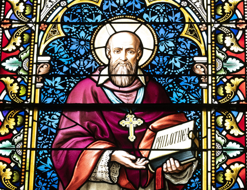 A stained glass window of a white, bearded man with a halo