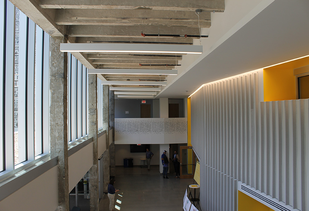 The interior lobby of Sedgwick Hall displays its past and present. Exposed limestone beams have stood for more than 100 years old, while new "acoustic fin" noise-shielding wall panels are made from recycled plastic bottles. (NCR photo/Brian Roewe)
