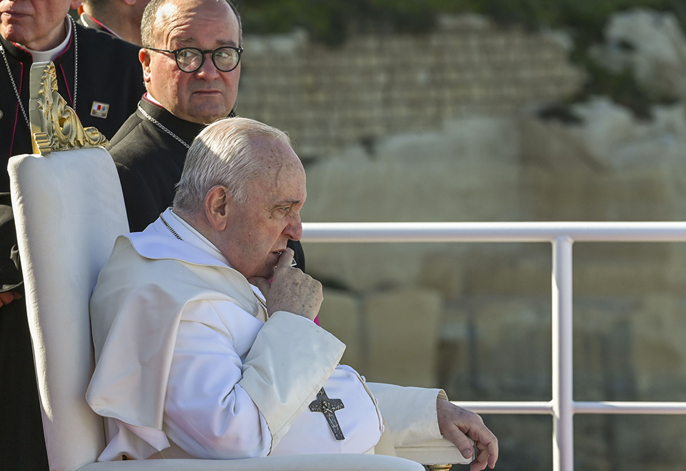 Pope Francis sits next to Maltese Archbishop Charles Scicluna aboard a catamaran leaving Valletta's harbor for Gozo in Malta during a papal trip April 2, 2022. (Andreas Solaro/Pool via AP)