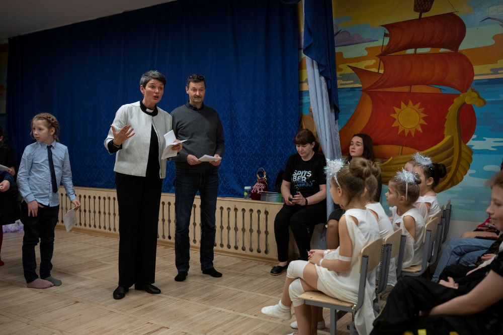The Rev. Siv Limstrand speaks next to a translator, Stein-Magne Wiik, during a Christmas performance at the Barentsburg school in Barentsburg, Norway, Saturday, Jan. 7, 2023. (AP/Daniel Cole)