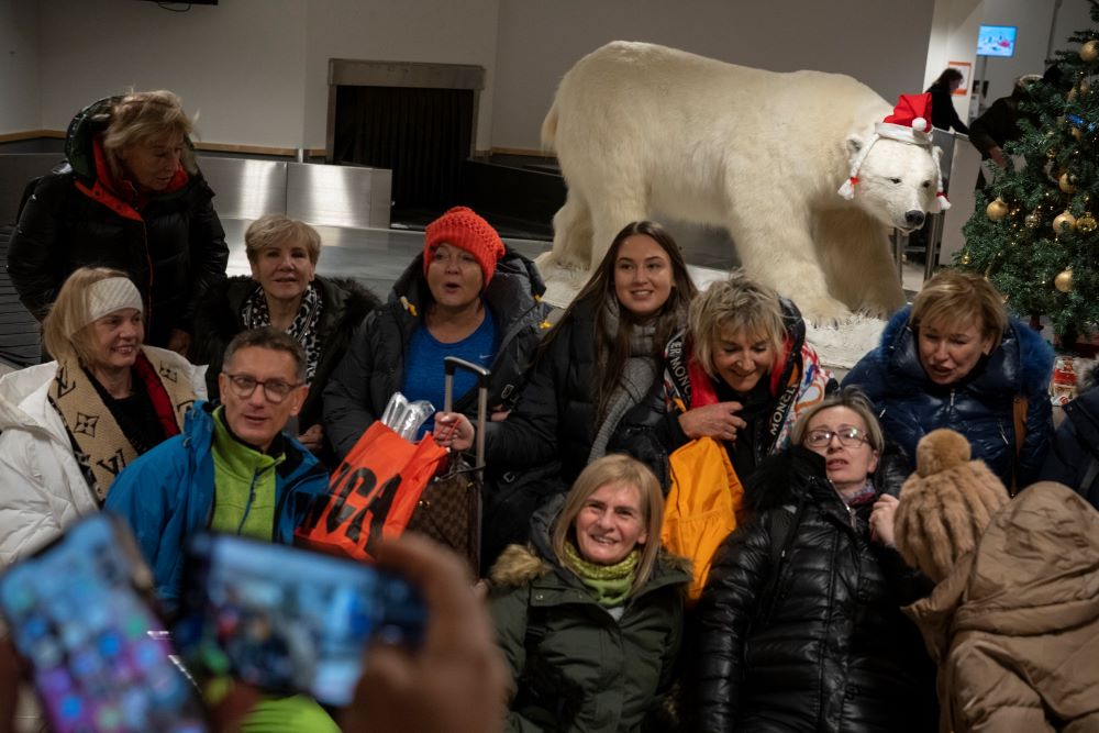 Tourists take pictures with a stuffed polar bear upon arriving to Longyearbyen airport, Norway, Friday, Jan. 6, 2023. (AP/Daniel Cole)