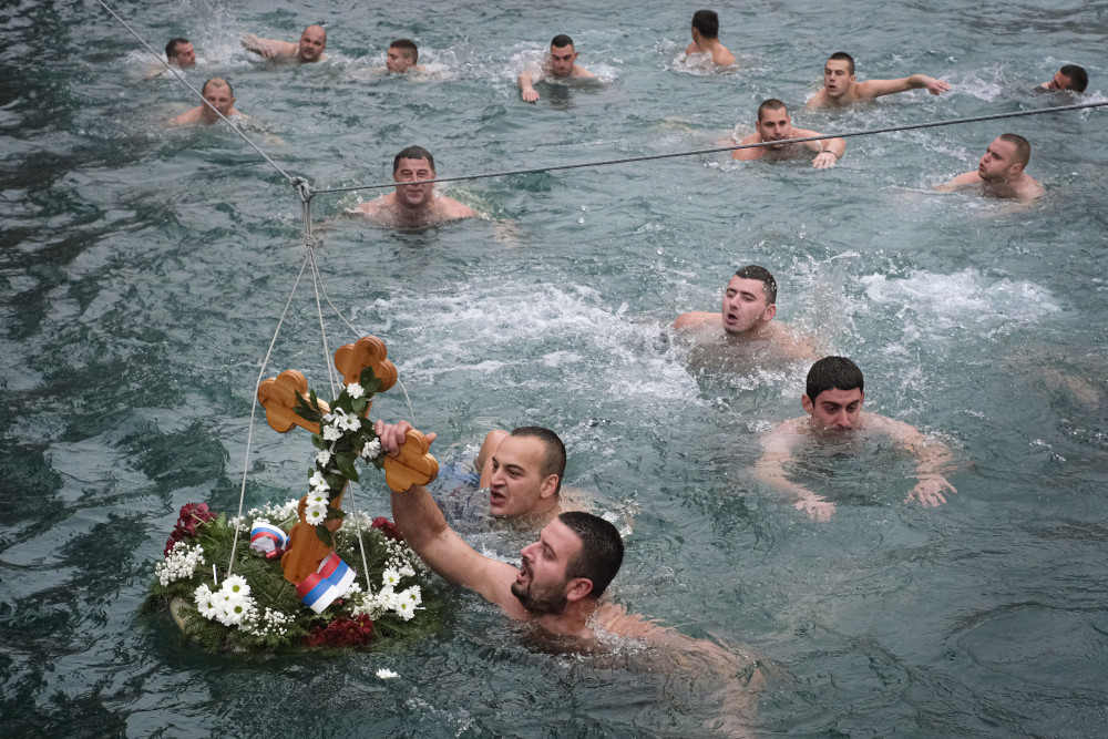 Men swim in the icy waters of the Drina River in Visegrad, Bosnia, Jan. 19, 2020, competing to reach a wooden cross. Serbian Orthodox Church followers plunged into icy rivers and ponds across the country to mark the upcoming Epiphany, cleansing themselves with water deemed holy for the day. (AP)