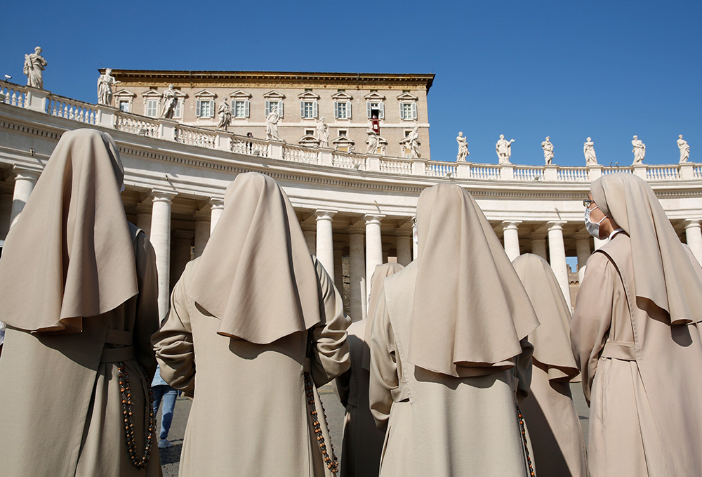 Monjas asisten a la oración del Ángelus dirigida por el Papa Francisco desde la ventana de su estudio con vista a la Plaza de San Pedro en el Vaticano el 25 de octubre de 2020. (CNS/Reuters/Remo Casilli)