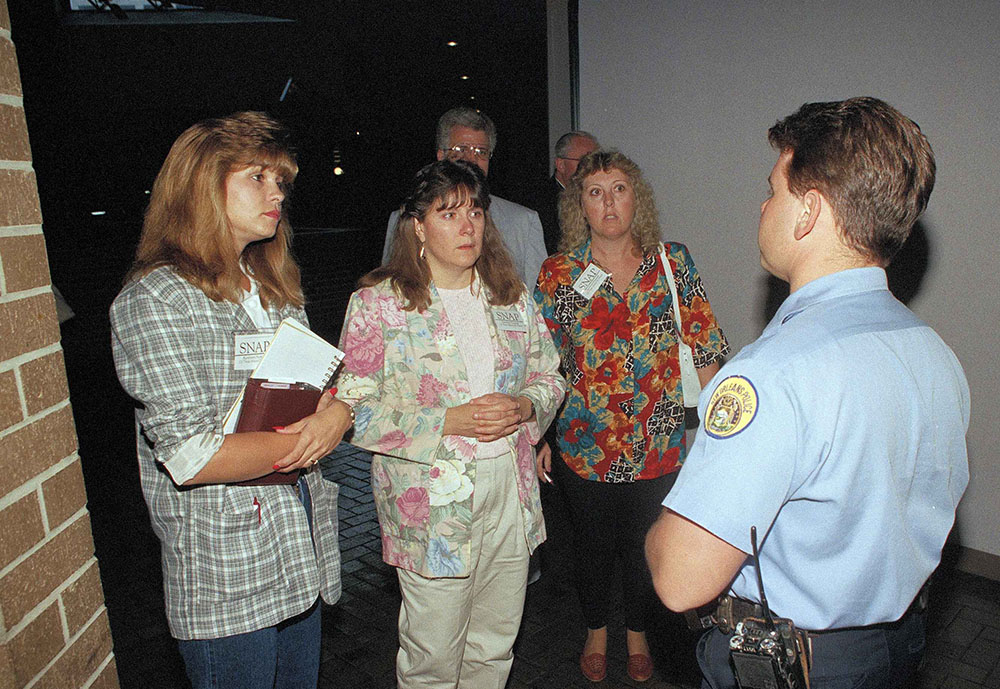 A New Orleans police officer stops, from left, Mary Staggs, Barbara Blaine and Sandy Graves from entering the National Conference of Catholic Bishops meeting in New Orleans on June 17, 1993. The women were members of the Survivors' Network for Those Sexually Abused by Priests, or SNAP. (AP/Paul Sancya)