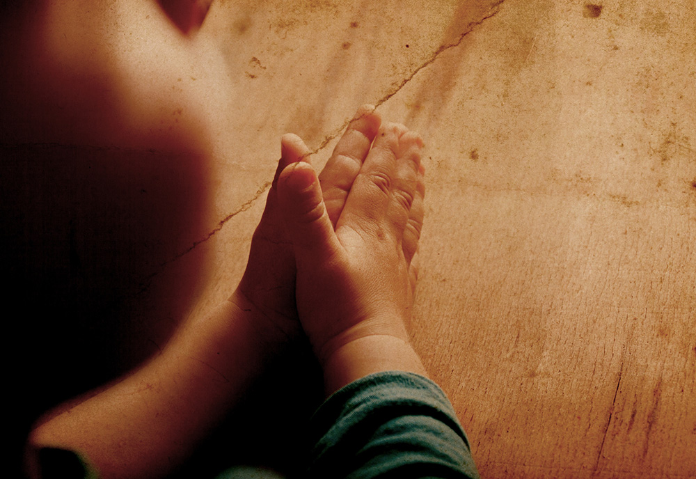 The hands of a child praying (Dreamstime/Arybickii)