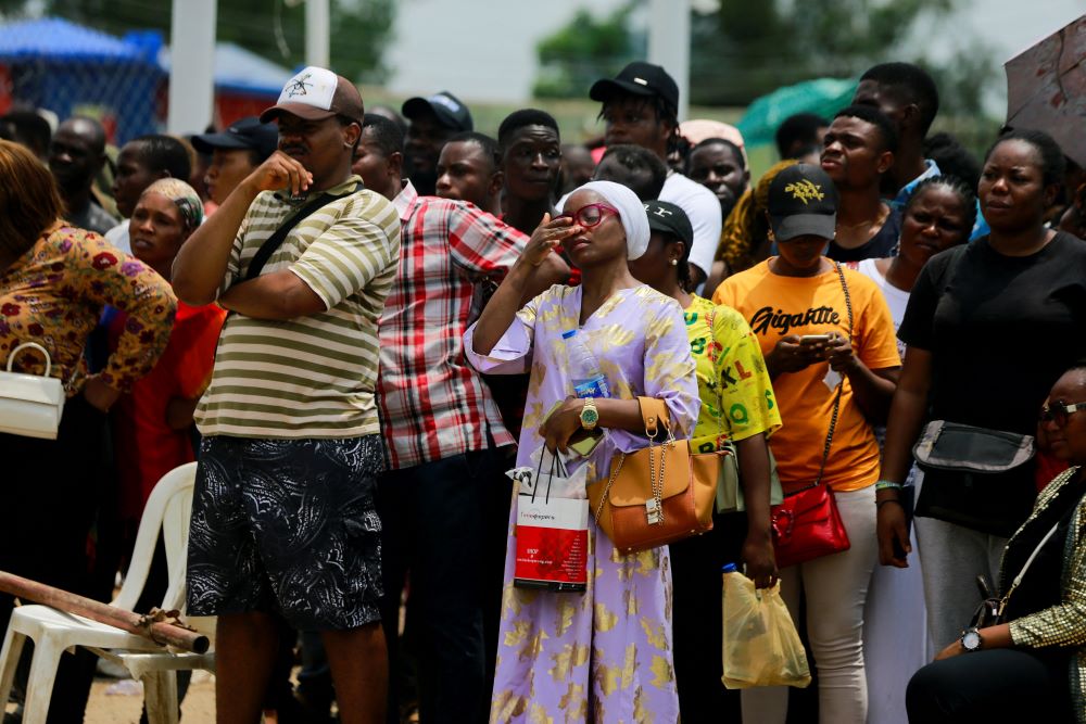 Nigerians stand in crowded line. 