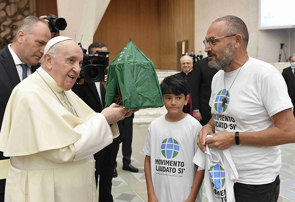 Pope Francis accepts the gift of a handmade "Abraham's tent" during his general audience in the Paul VI hall Sept. 1, 2021, at the Vatican. The gift was given by members of the Laudato Si' Movement. (CNS/Vatican Media)