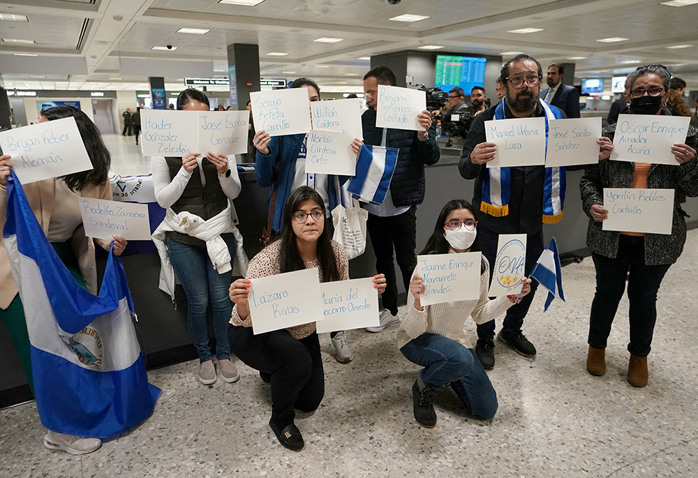 Activists hold up signs with the names of some of the more than 200 political prisoners released from Nicaragua, as they await their arrival at Dulles International Airport Feb. 9 in Virginia. (OSV News/Reuters/Kevin Lamarque)