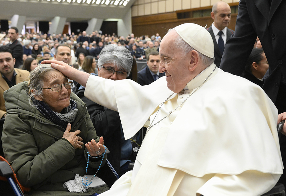 Pope Francis blesses a woman after his weekly general audience Feb. 15 in the Vatican audience hall. (CNS/Vatican Media)